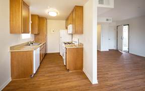 A kitchen with wooden cabinets and a white fridge.