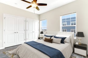 a bedroom with a large bed and a ceiling fan at Preservation Square Apartments