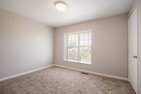 A room with a window and carpeted floor.