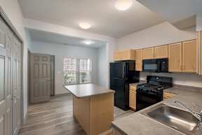 A kitchen with black appliances and wooden cabinets.