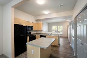 A kitchen with black appliances and wooden cabinets.