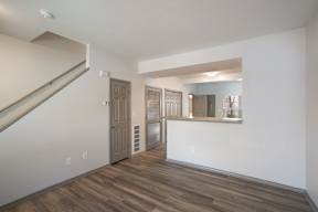 A room with a staircase and a door leading to another room.