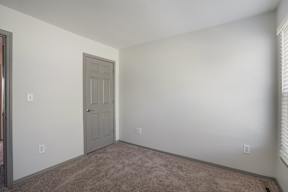 A room with a carpeted floor and a door.
