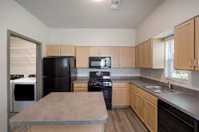 A kitchen with black appliances and wooden cabinets.