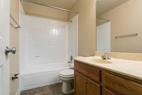 A bathroom with a toilet, sink, and shower.