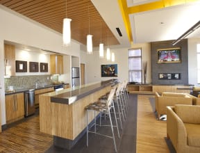 a lobby with a bar and chairs and a kitchen