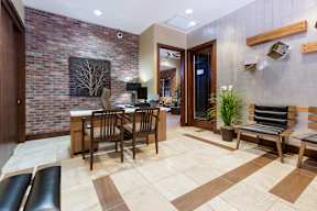 A modern living room with a brick wall and a dining table.