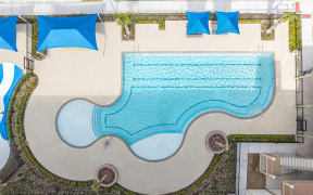 an aerial view of a swimming pool with umbrellas