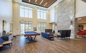Community room at Perkins Square Apartments with pool table and lounge seating areas