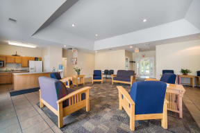 a lobby with chairs and tables and a kitchen
