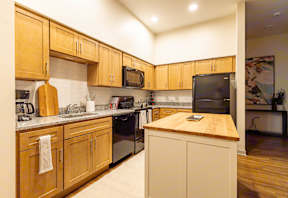 A kitchen with wooden cabinets and a black oven.