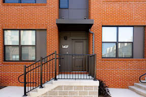 A red brick building with a black door and windows.