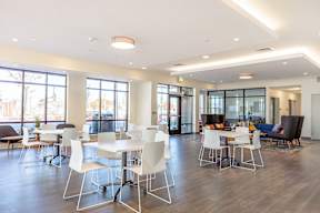 A conference room with white chairs and a long table.