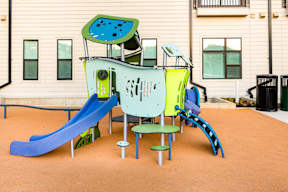 A playground with a blue slide and a green and yellow play structure.