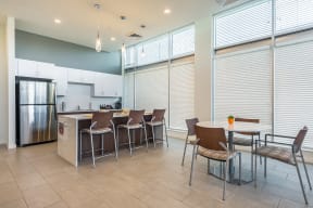a kitchen and dining area with a table and chairs and a refrigerator at Legacy Pointe at Poindexter Apartments & Townhomes