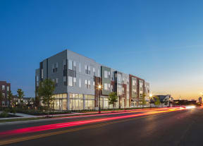 a rendering of a building on a city street at night at Legacy Pointe at Poindexter Apartments & Townhomes