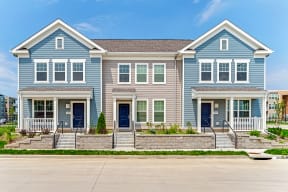 a blue and white house with a sidewalk in front of it