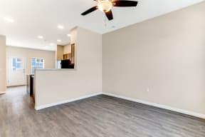 an empty living room with a ceiling fan