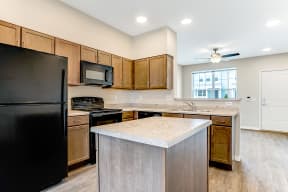 a kitchen with an island and a black refrigerator