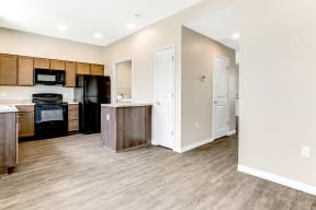 a kitchen and living room with a wood floor and white walls