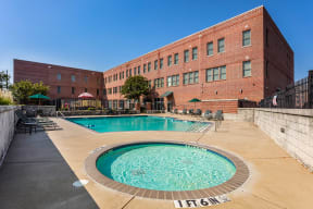 a swimming pool with a brick building in the background