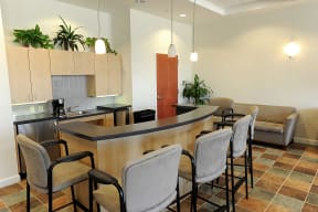 a kitchen with a bar and chairs in a lobby