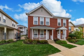 a brick house with a sidewalk in front of it at Renaissance Place at Grand Apartments & Townhomes