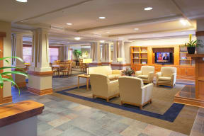 a lobby with couches and chairs and a television