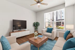 A living room with a television, two chairs, a coffee table, and a potted plant.