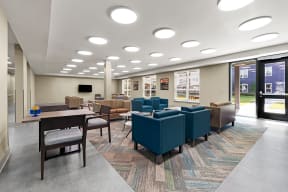 a large lounge area with chairs and tables and windows at South City Senior in Memphis, TN