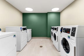 a laundry room filled with washes and dryers at South City Senior in Memphis, TN