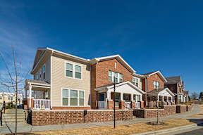 A row of houses with a clear blue sky above them.