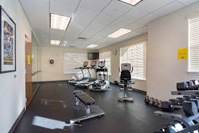 A gym with a variety of equipment including weights and a treadmill.