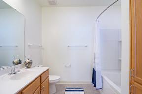 A bathroom with a white sink, toilet, and bathtub.