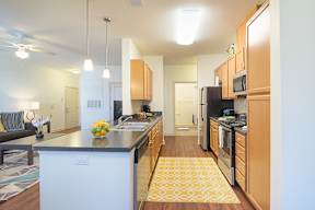 A kitchen with a white dishwasher and wooden cabinets.