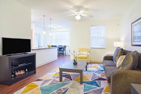 A living room with a television, a couch, and a coffee table.