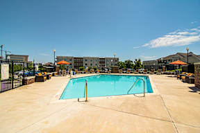 A large swimming pool in a fenced in area.