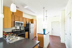 A kitchen with wooden cabinets and a black countertop.