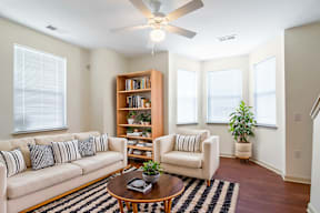 A living room with a couch, chair, and bookshelf.