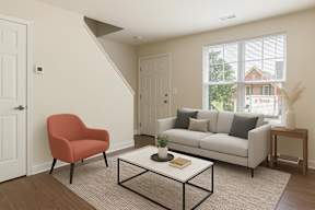 A living room with a red chair, a white couch, and a coffee table.