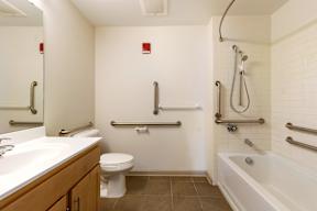 A white bathroom with a toilet, sink, and bathtub.