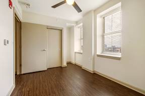 A room with a brown door and a ceiling fan.