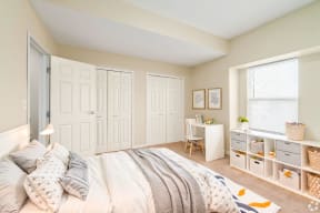a bedroom with white closets and a bed     and a desk