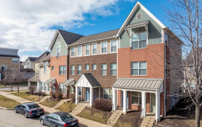 a row of brick apartment buildings with cars parked in front