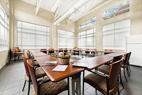 a dining room with tables and chairs and large windows