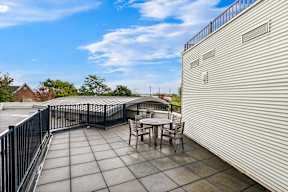a patio with a table and chairs on a roof