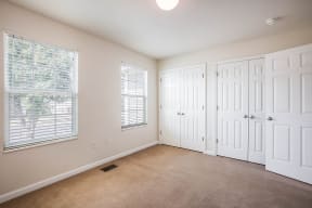 an empty living room with two doors and a window