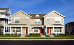 a row of houses with red doors on a street