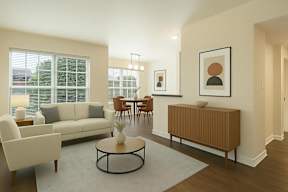 A living room with a white sofa, a wooden side table, and a coffee table.