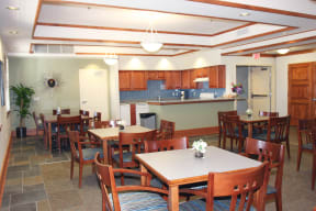 a dining room with tables and chairs and a kitchen